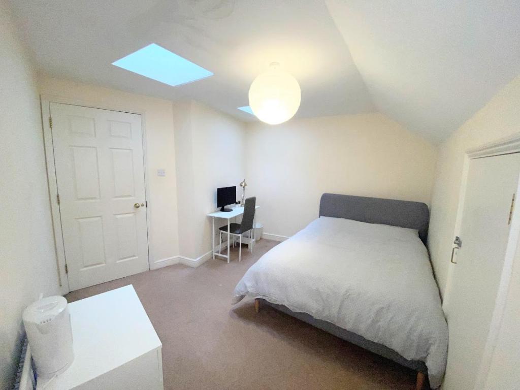 a small bedroom with a bed and a desk at Cozy Double Room next to Putney Bridge and High Street in London
