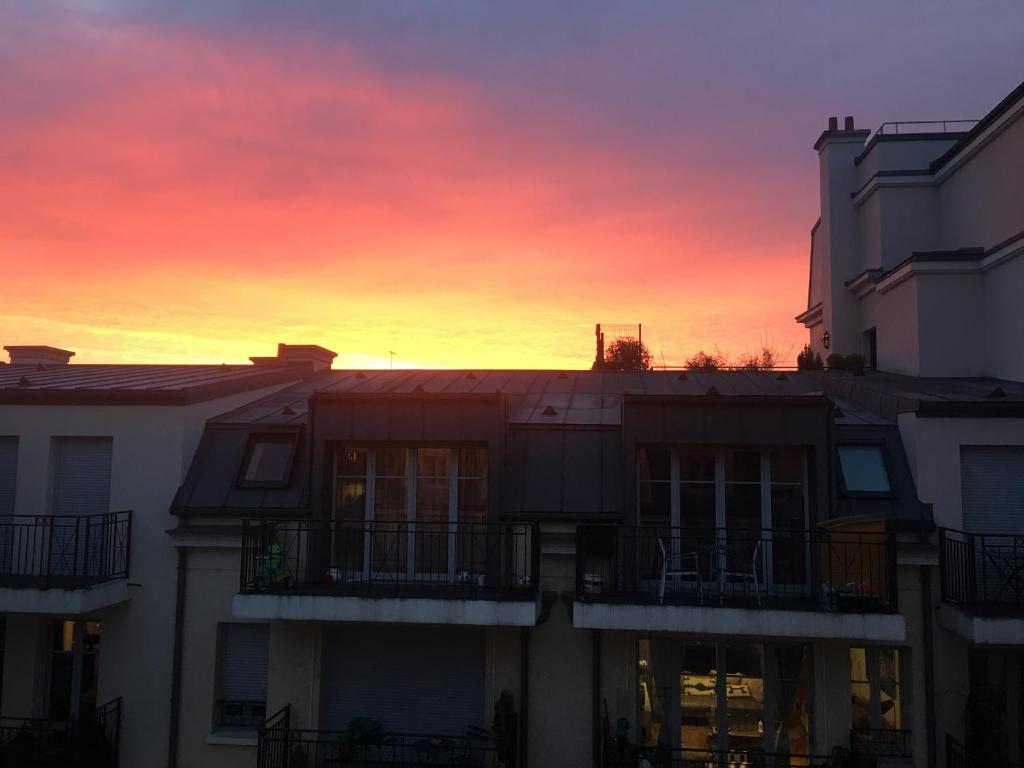 a sunset in a city with a building at Appartement moderne et agréable, idéalement placé pour JO 2024 in Puteaux