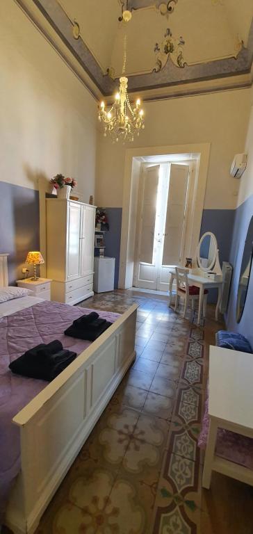 a bedroom with a large bed and a chandelier at Affittacamere Museo in Taranto