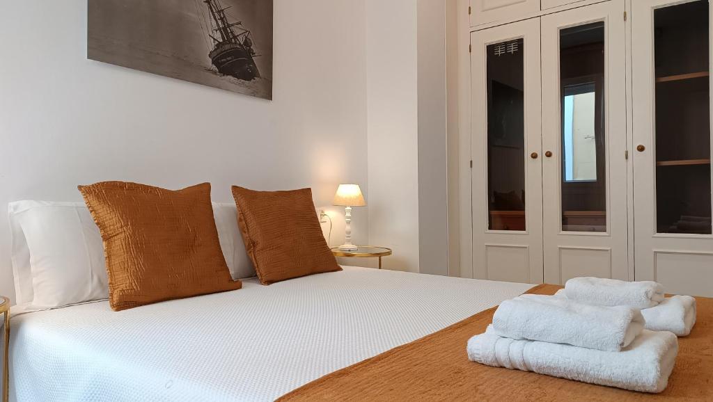 sypialnia z białym łóżkiem i ręcznikami w obiekcie Sherryflat Torneria- Parking w mieście Jerez de la Frontera
