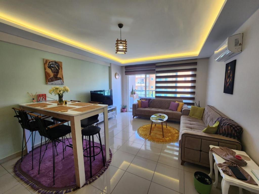 a living room with a table and a couch at Cozy fancy Sea view next to the Beach and the Mall, in the mid of Alanya Mahmutlar! in Alanya