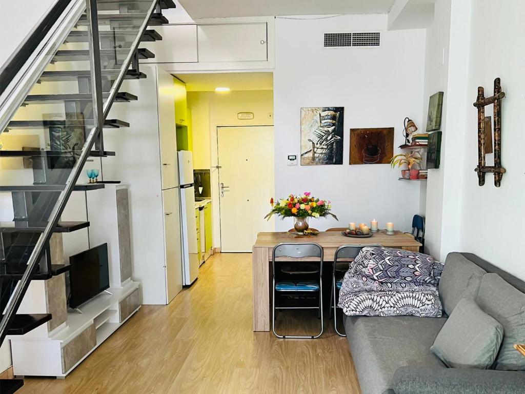 uma sala de estar com um sofá e uma mesa em Espectacular apartamento con piscina y garaje em Madri