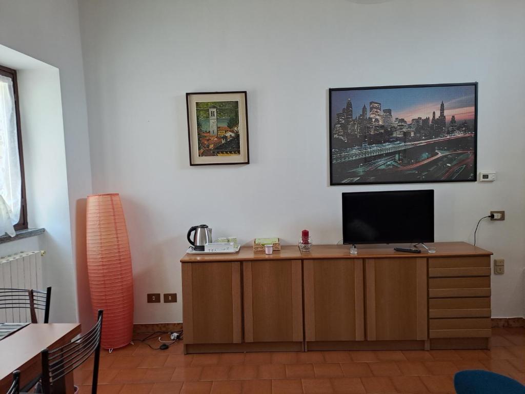 Habitación con escritorio y TV en la pared. en MansardHouse zona Bellagio, en Magreglio