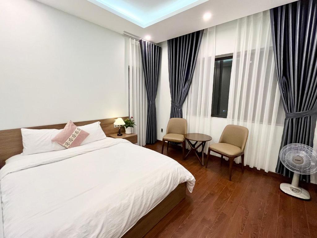 a bedroom with a bed and a table and chairs at SAFFRON Dalat in Da Lat