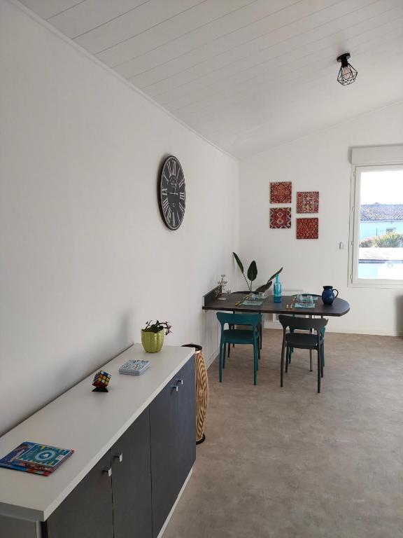 une cuisine et une salle à manger avec une table et une horloge dans l'établissement Grand studio centre ville Bretignolles, à Bretignolles-sur-Mer