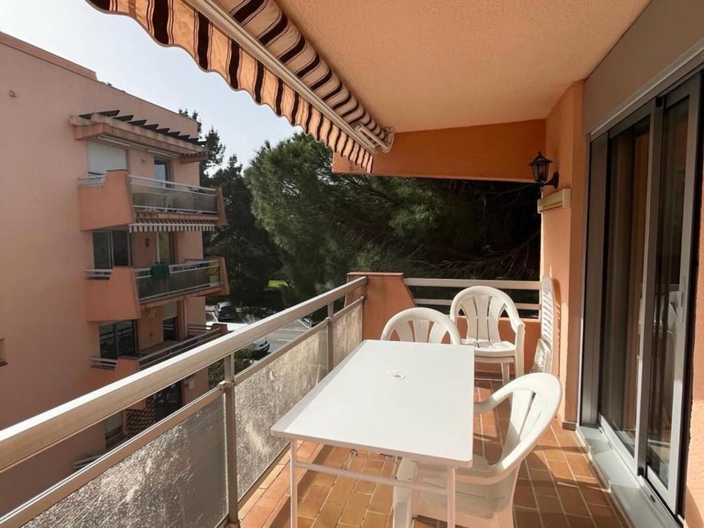 einen weißen Tisch und Stühle auf dem Balkon in der Unterkunft Appartement Bormes-les-Mimosas, 2 pièces, 4 personnes - FR-1-610-99 in Bormes-les-Mimosas