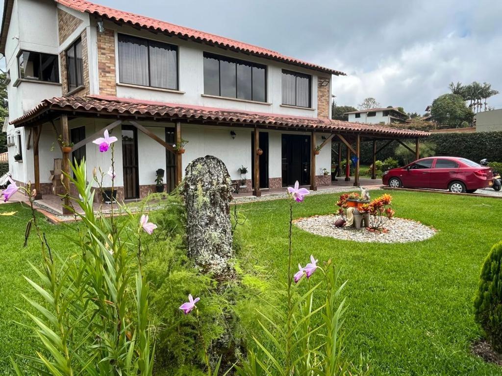 a house with a yard with flowers in front of it at Villa Mali Circasia Quindio in Circasia