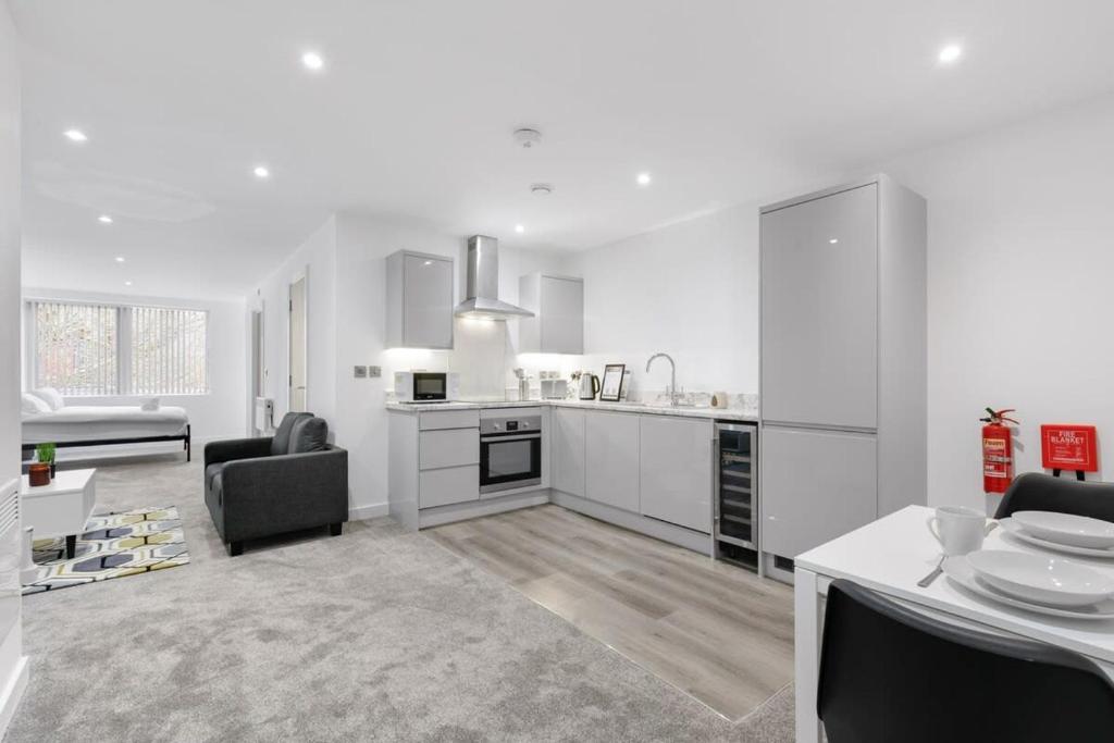 a kitchen with white cabinets and a table and chairs at Spacious Studio Apartment in Central Newbury in Newbury