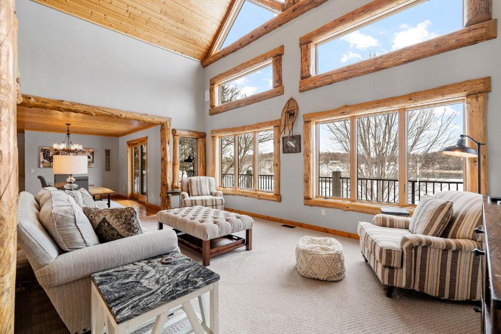 a living room with vaulted ceilings and windows at Maple Lake Chalet in Buffalo
