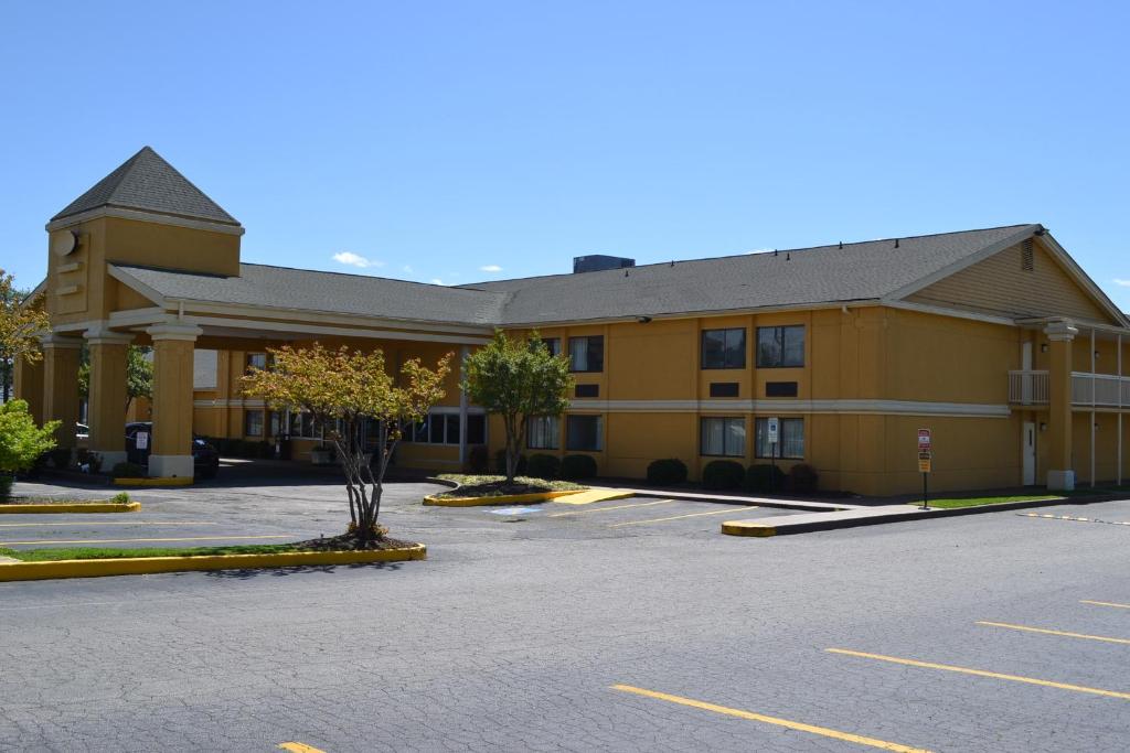 a large yellow building with a parking lot at Dayspring Extended Stay in Greensboro