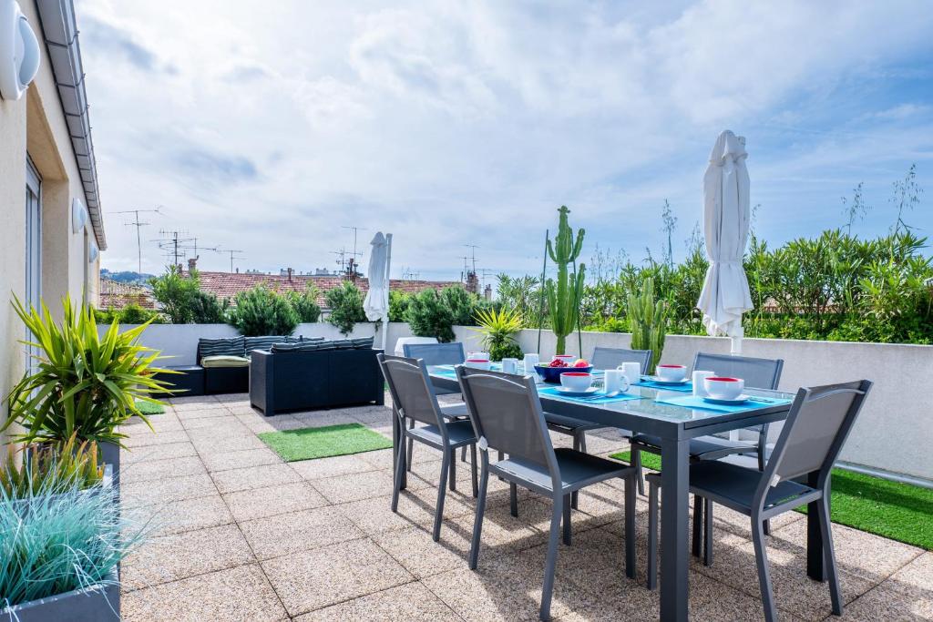 un patio con mesa y sillas en RARE! 120m ROOFTOP apartment 5-minute walk to downtown, en Cannes