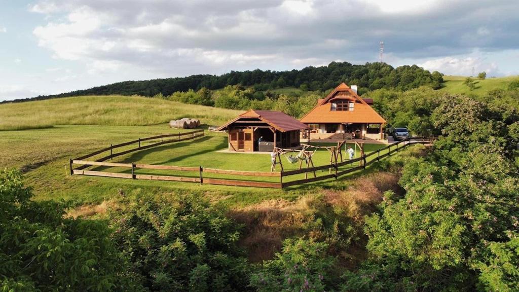 una casa en medio de un campo con una valla en Bakonyszentkirályi Menedék, en Bakonyszentkirály