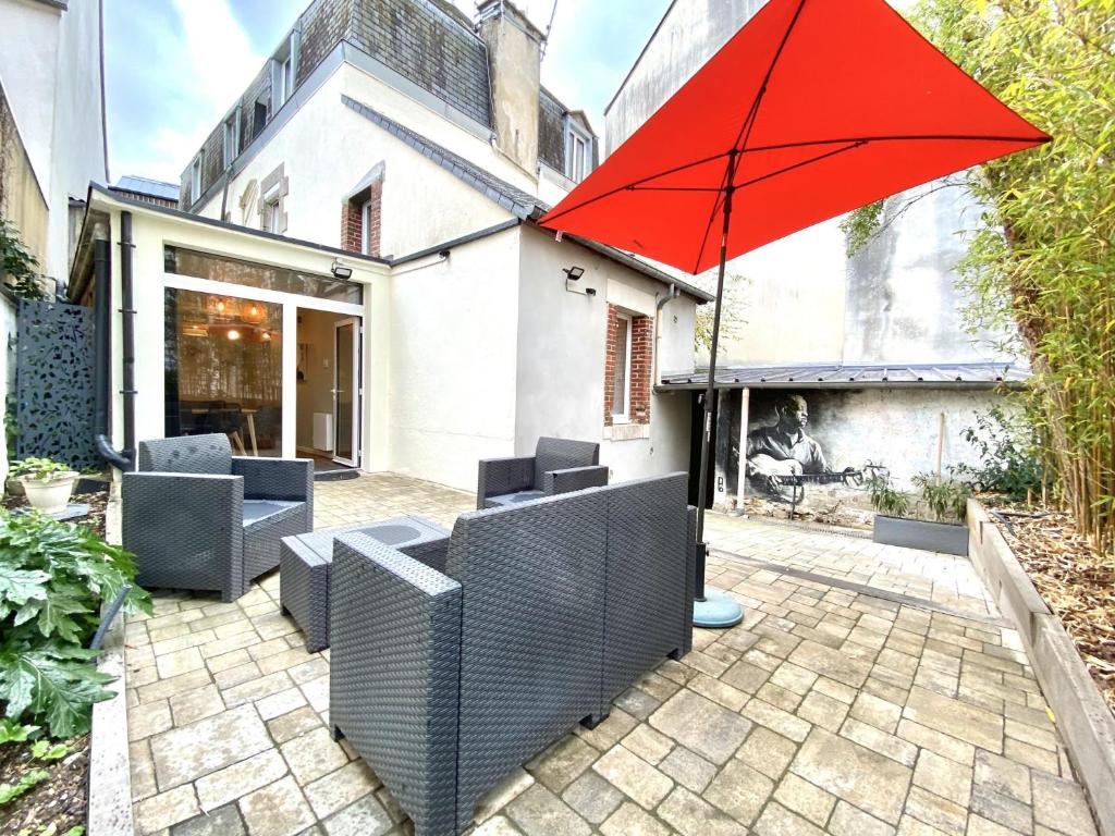 - un parasol rouge assis au-dessus d'une terrasse dans l'établissement Apt centre historique Vannes COUR et GARAGE privés, à Vannes