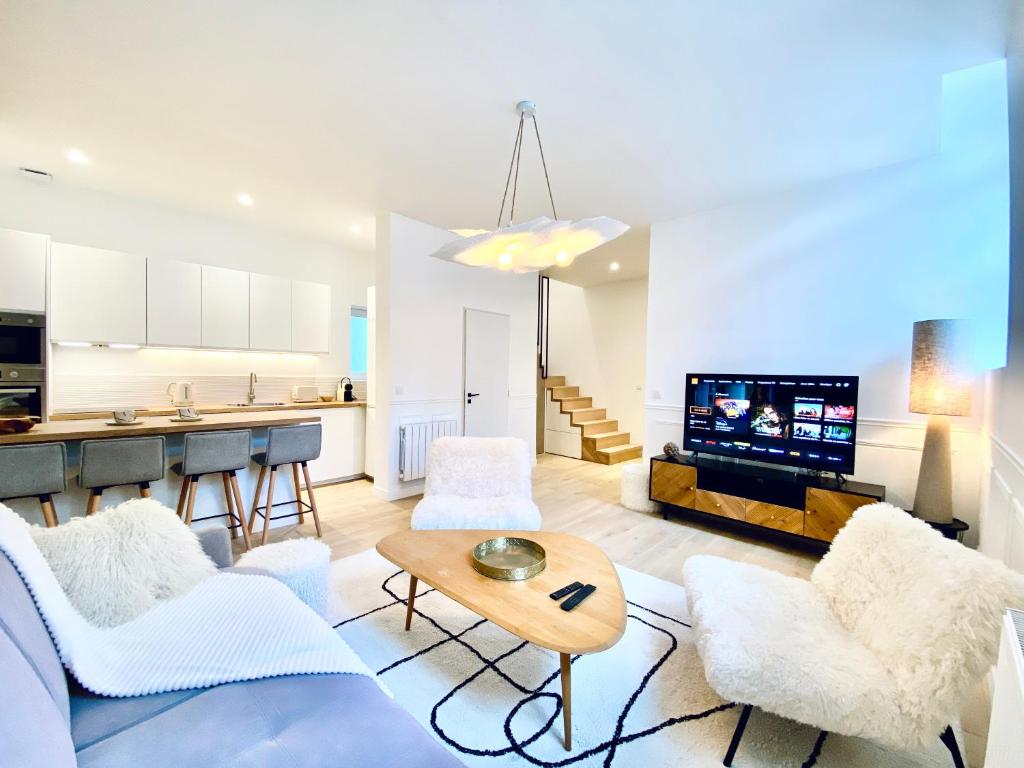 Il comprend un salon avec un mobilier blanc et une cuisine. dans l'établissement Velvet - By BEST KEYS - Maison Duplex Élégante - Plein Centre Ville - Déco Minimaliste & Cosy - Literie Haut de Gamme - 2 chambres séparées - Lit Queen Size & 1 canapé convertible - Smart TV - Machine à Café Nespresso - WiFi Fibre - Check-in Autonome, à Sens
