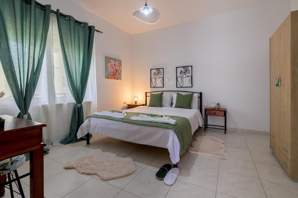 a bedroom with a large bed with green curtains at Delfini Bliss 1 in Alexandroupoli
