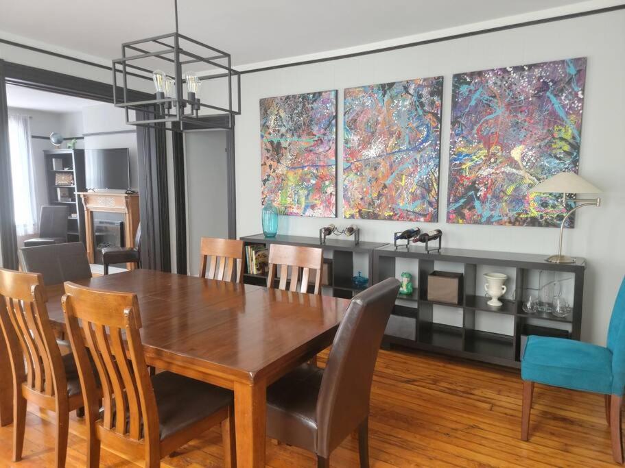 a dining room with a wooden table and chairs at 1895 meets 2023 Townhouse. in Hamilton
