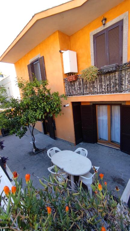 a table and chairs in front of a building at Domus Laurenza in Acilia