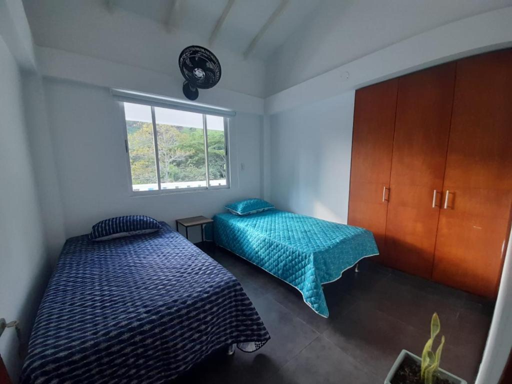 een slaapkamer met 2 bedden en een raam bij Casa Numbana in Norcasia