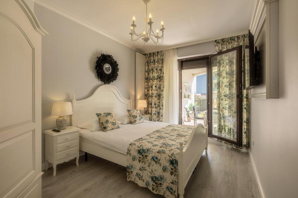 een witte slaapkamer met een bed en een raam bij Apartament La Plaja in Mamaia Nord – Năvodari