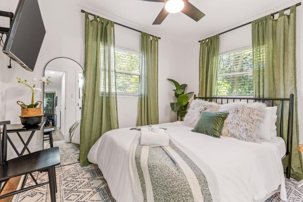a bedroom with a bed with green curtains at Modern Midtown Charm Free Parking Fsu, Downtown in Tallahassee