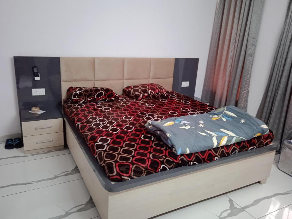 uma cama com um edredão vermelho e almofadas em Ishita villa em Lucknow