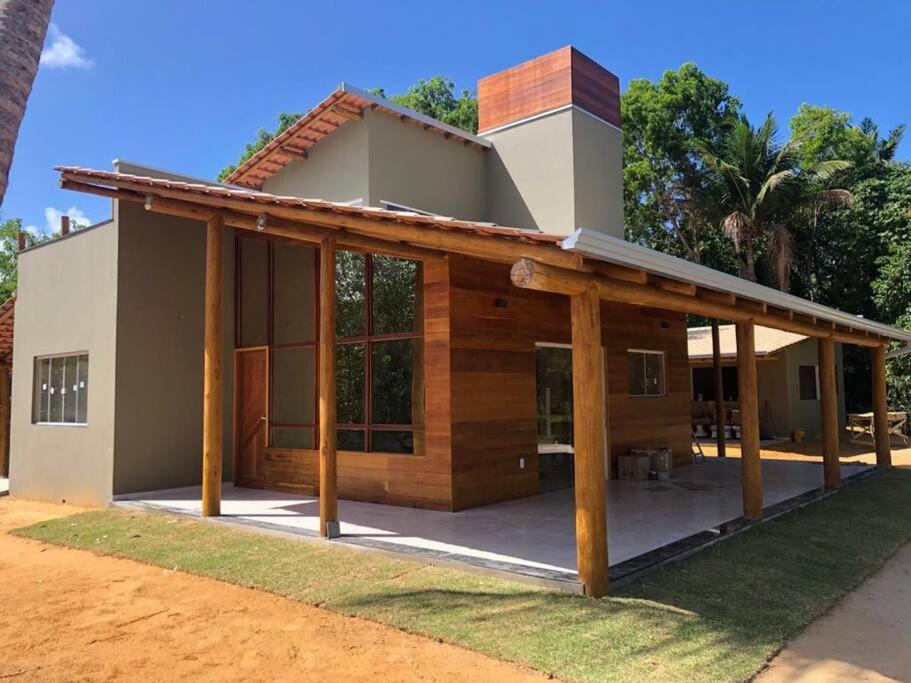 a house with a covered porch in front of it at Belíssima casa no condomínio Mar Doce de Abrolhos in Caravellas