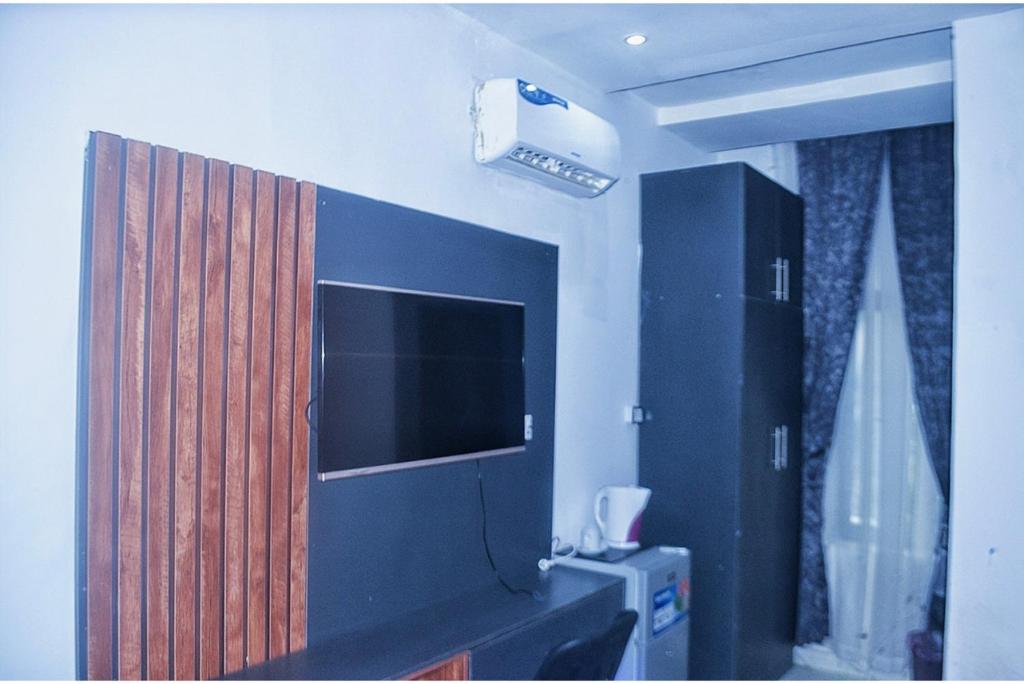a room with a tv and a cabinet with a television at Empire Suites And Apartment in Abuja