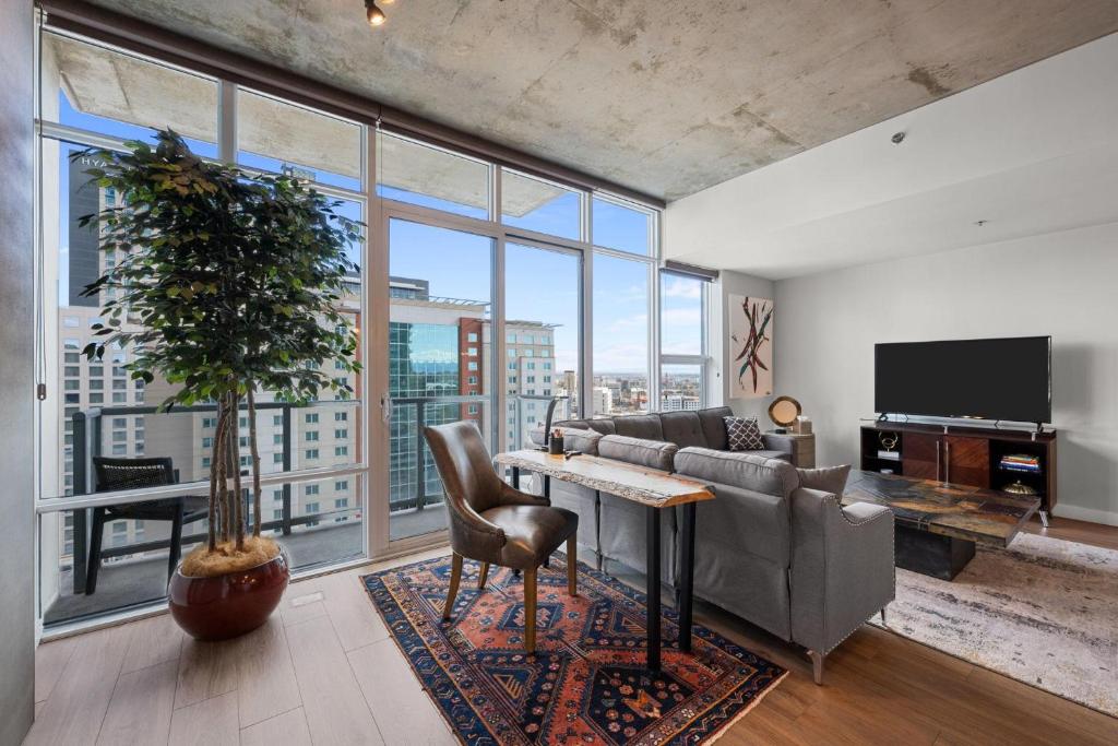 a living room with a couch and a table with a plant at Spire - Unit 1810 in Denver