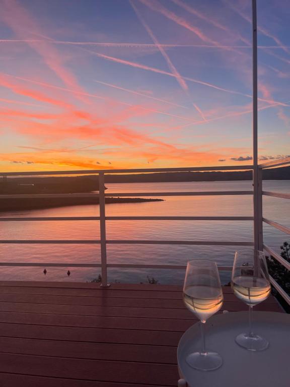 dos copas de vino sentadas en una mesa frente al océano en Apartment Mañana STINICA en Jablanac