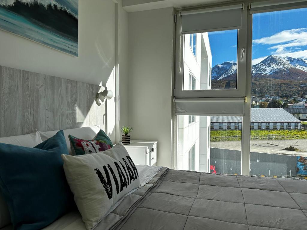 een slaapkamer met een bed en uitzicht op een berg bij AIRES DEL SUR in Ushuaia