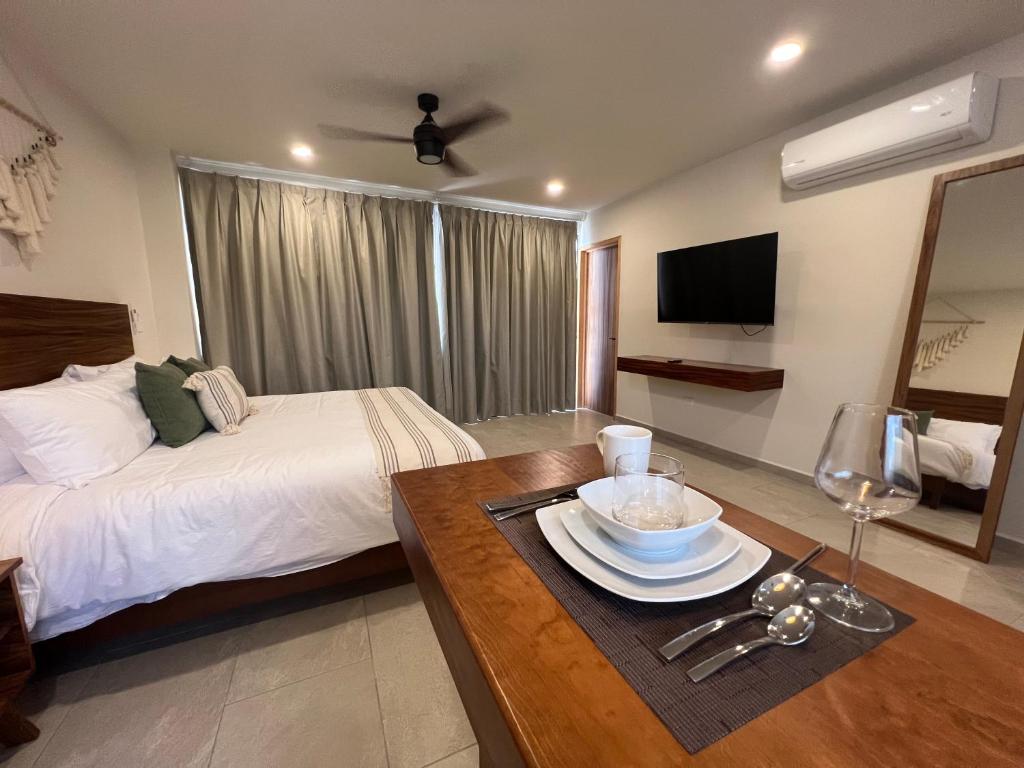 um quarto de hotel com uma cama e uma mesa com uma tigela em New Studio p/2, jacuzzi, alberca, roof top em Tulum