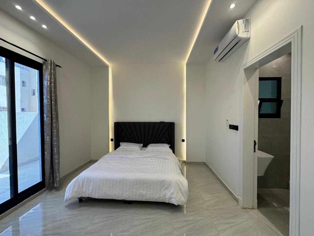 sypialnia z białym łóżkiem i dużym oknem w obiekcie 沙漠之梦Desert Dreams w Rijadzie
