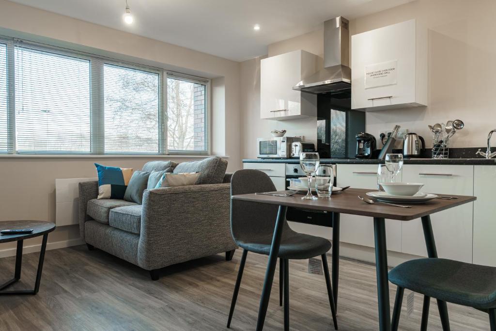 a kitchen and living room with a table and a couch at Modern Manchester Apartment, Free Parking For Two, Smart TVs, Central Location in Manchester