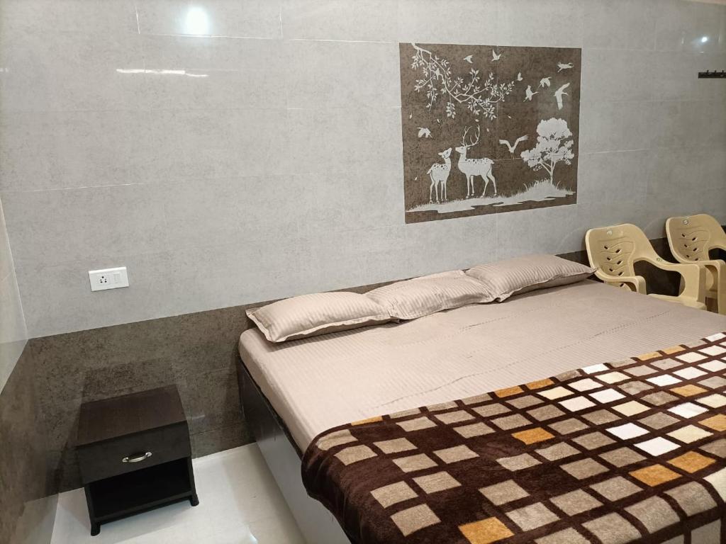 a bed in a room with two chairs and a painting at Hillview Cottage in Kuttālam