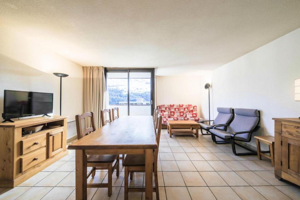 un salon avec une table, des chaises et une télévision dans l'établissement Résidence Pégase - maeva Home - Appartement 3 pièces 8 personnes Confort MAE-3481, à Flaine
