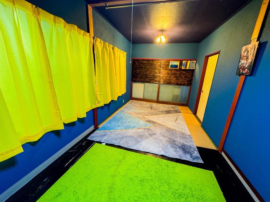 新島村にあるOKESYOU - Vacation STAY 55986vの黄色と青の壁と緑の床が特徴の客室