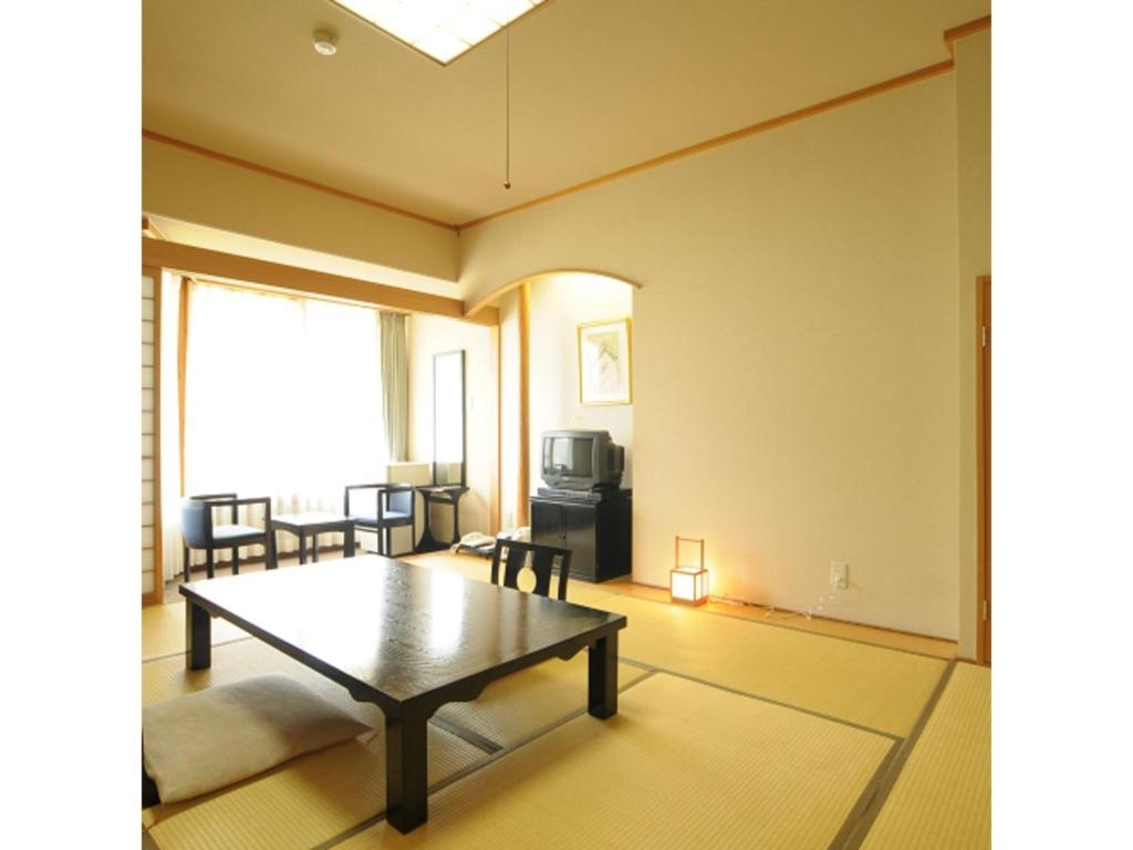 Akinomiya Sanso - Vacation STAY 46121v في Yuzawa: غرفة معيشة مع طاولة قهوة وتلفزيون