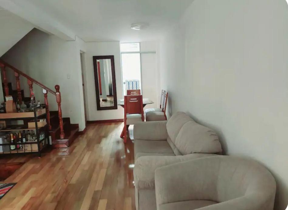 a living room with two couches and a staircase at Hermosa Casa en el Polo in Lima