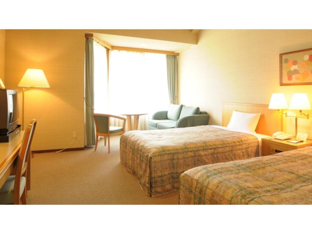 ein Hotelzimmer mit 2 Betten und einem Sofa in der Unterkunft Akinomiya Sanso - Vacation STAY 68712v in Yuzawa