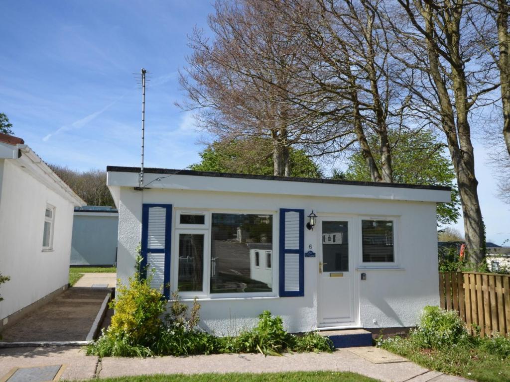 ein kleines weißes winziges Haus mit blauem Trimm in der Unterkunft 2 Bed in Brixham BX081 in Brixham