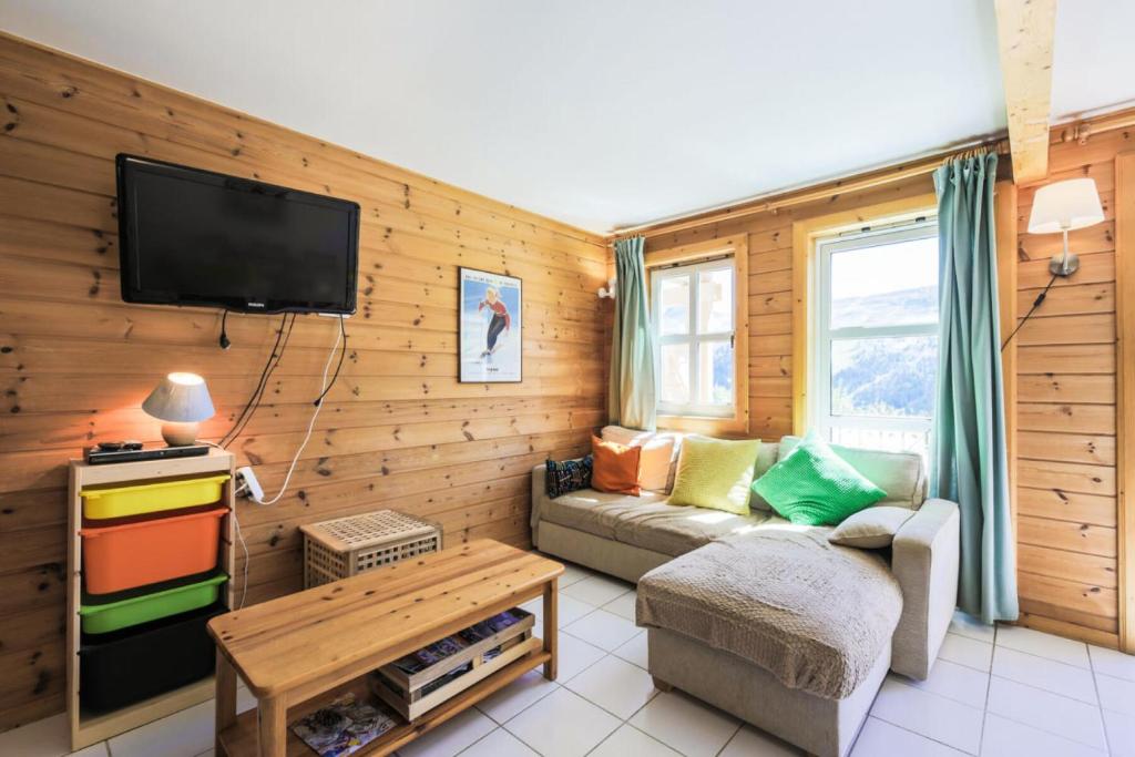 un salon avec un canapé et une télévision dans l'établissement Les Chalets de Flaine Hameau - maeva Home - Chalet 3 Pièces 8 Personnes - Confort MAE-3654, à Flaine