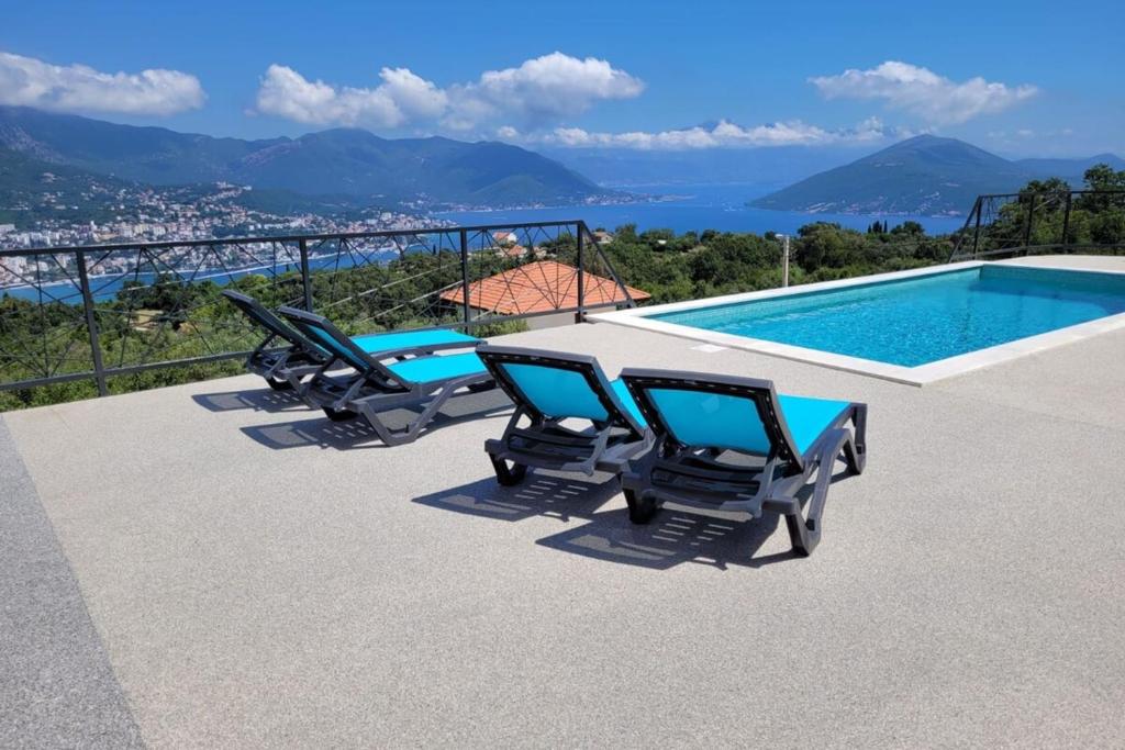 a group of chairs sitting next to a swimming pool at Bay View Village -Villa Eléanora 4 in Herceg-Novi