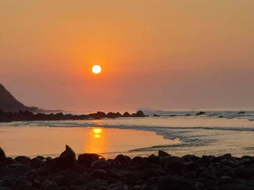 een zonsondergang op een strand met zonsondergang bij Bongo Experience in Jucuarán