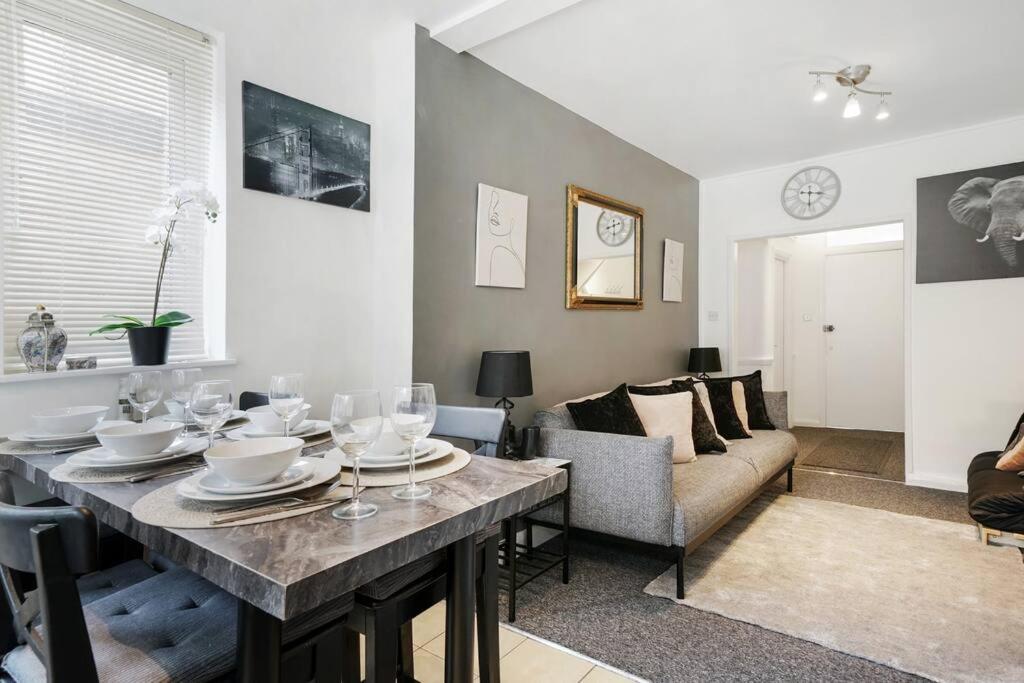 a living room with a table and a couch at 2 Bed Garden Flat Sleeps 6 Close to Brixton in London