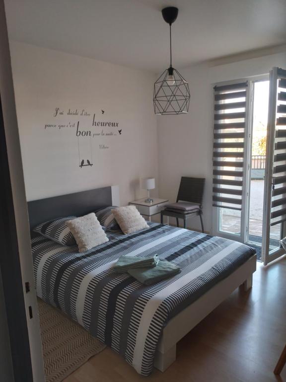 a bedroom with a bed with a sign on the wall at Chambre agréable au calme in Saint-Hilaire-Petitville