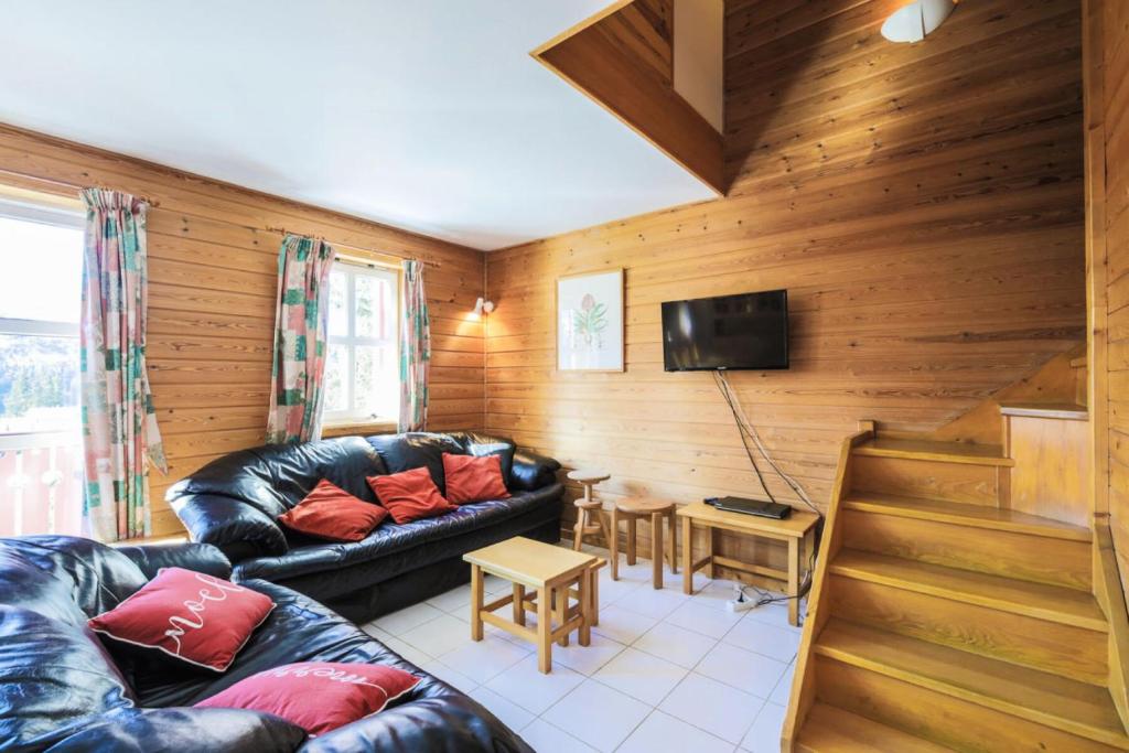 un salon avec un canapé en cuir et une télévision dans l'établissement Les Chalets de Flaine Hameau - maeva Home - Chalet 4 Pièces 8 Personnes - Confort MAE-3662, à Flaine