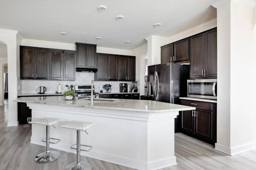 a kitchen with a large white island with bar stools at Luxury Master Room 1 In Austin's Mckinney Falls in Austin