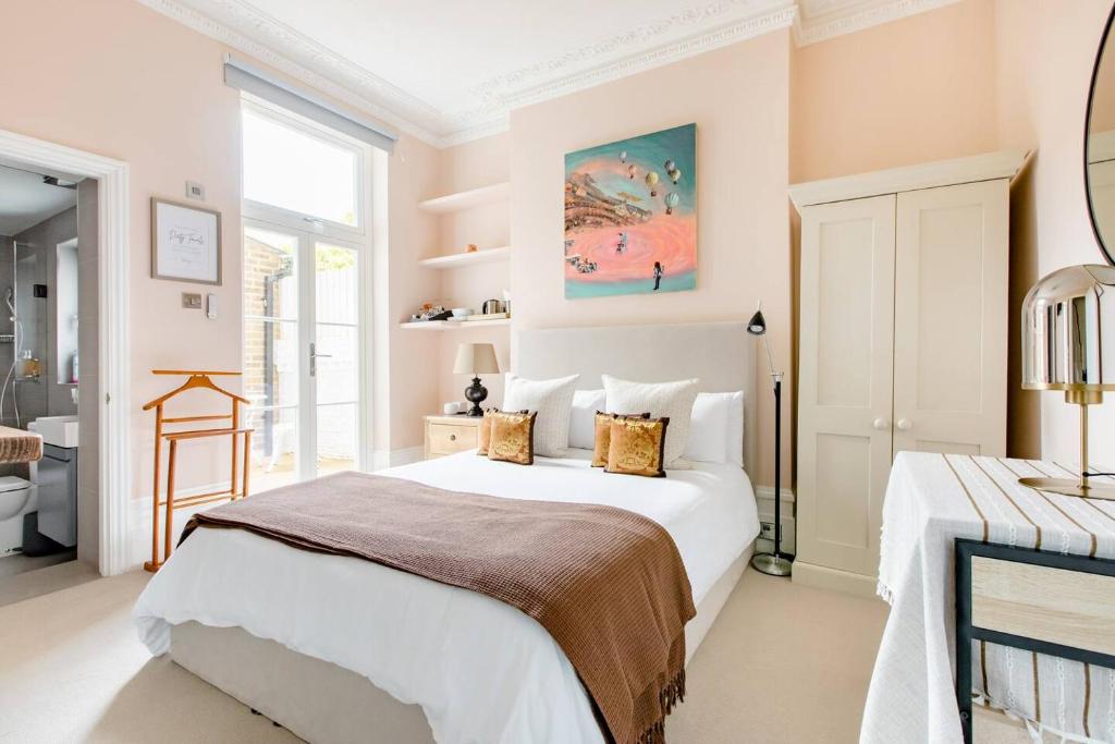 ein Schlafzimmer mit einem großen weißen Bett und einem Fenster in der Unterkunft Luxury King-bed Ensuite With Quiet Private Patio in London