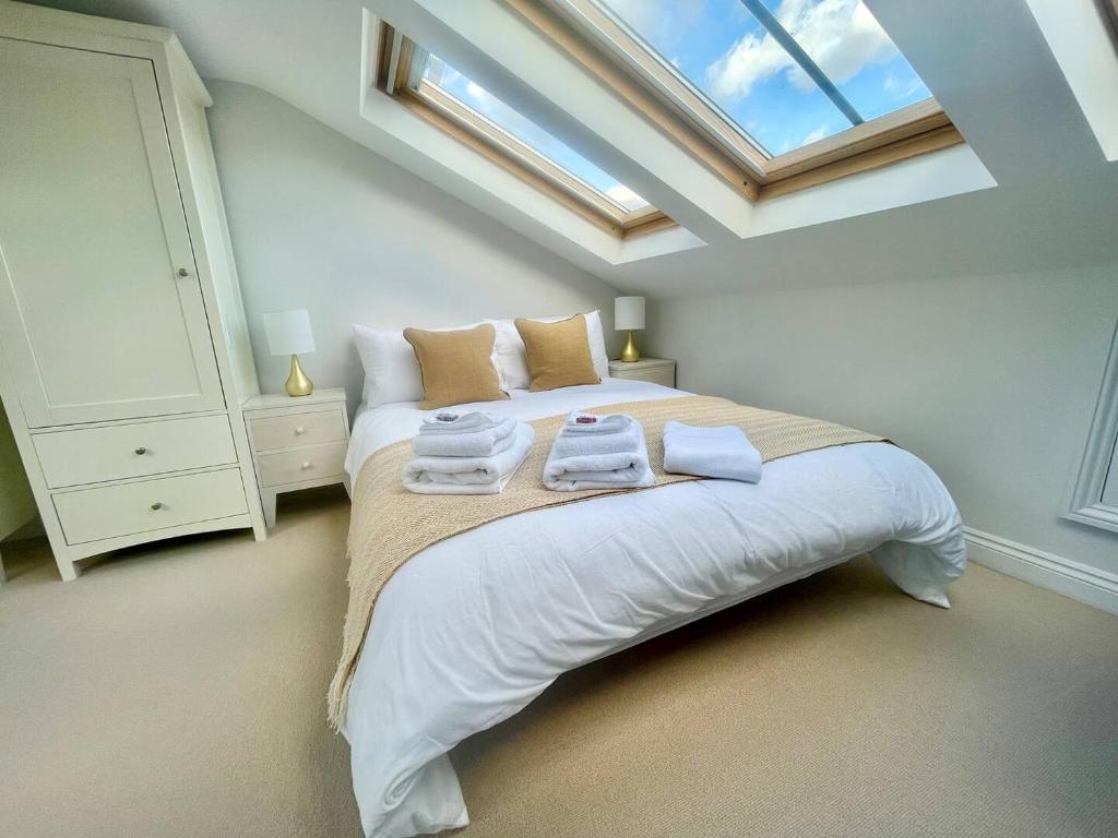 a bedroom with a bed with two towels on it at Bright Quiet Loft Room Ensuite Serene Clapham Area in London
