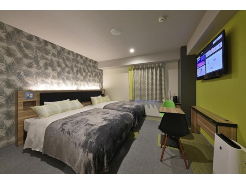 名護的住宿－Green Rich Hotel Okinawa Nago - Vacation STAY 49920v，一间卧室配有一张大床和一台平面电视